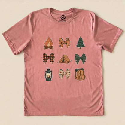 A pink graphic t-shirt features nine outdoor-themed images, including a campfire, tree, lantern, and various bows, titled "Camping Bows Shirt.