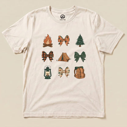 A graphic t-shirt featuring a collection of camping-themed bows, including a fire, tent, and lantern, titled "Camping Bows Shirt.