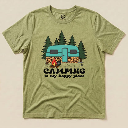 A green graphic t-shirt featuring a vintage camper, trees, and the slogan "Camping is my happy place.