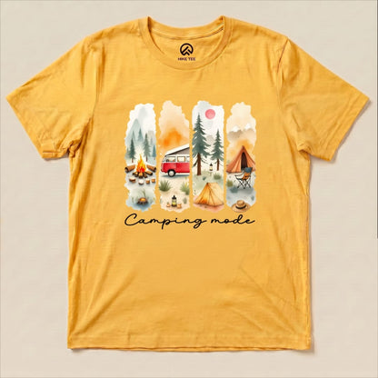A yellow graphic t-shirt featuring a watercolor design with camping scenes and the phrase "Camping mode" printed below.