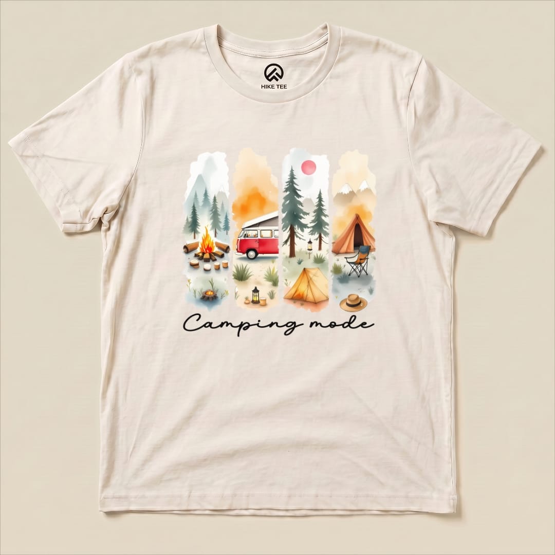 A flat lay of the Camping mode Watercolor Shirt featuring a colorful camping scene with a red van, tents, and trees.