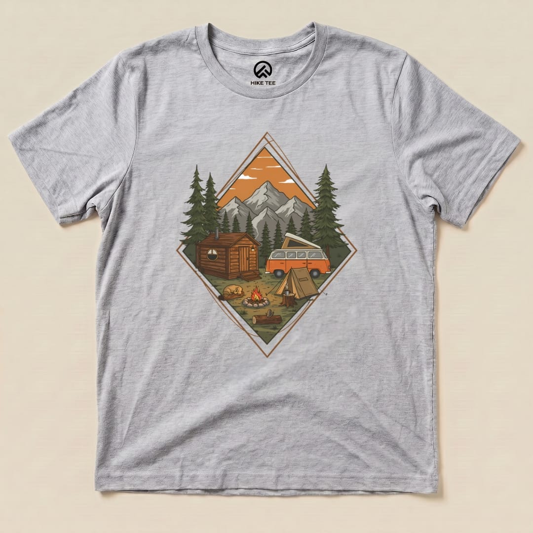 A graphic t-shirt featuring a Camping Scenery Shirt design with a cozy cabin, campsite, and mountains at sunset.