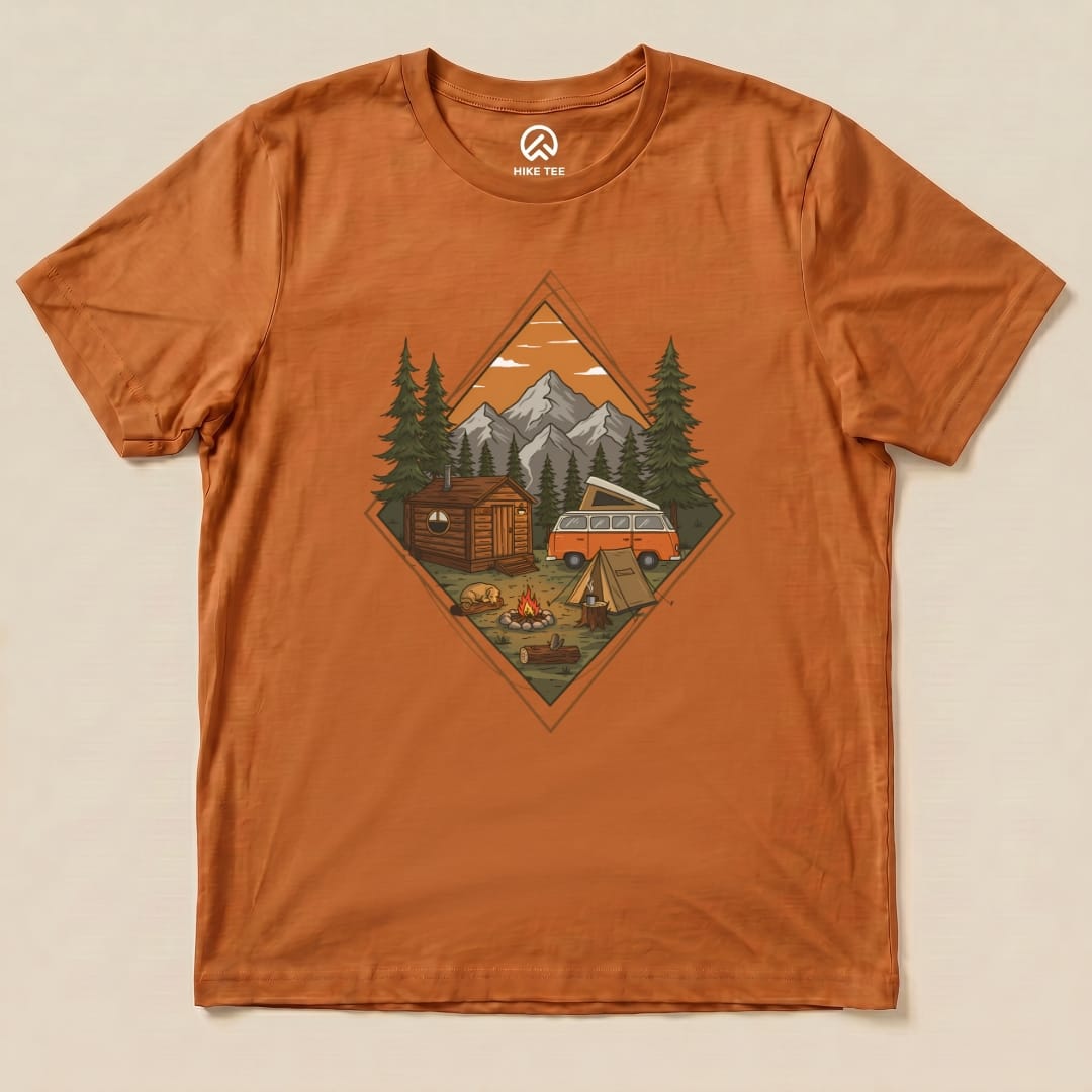 The Camping Scenery Shirt features an illustrated camping scene with mountains, a cabin, a campground, and a vintage van.