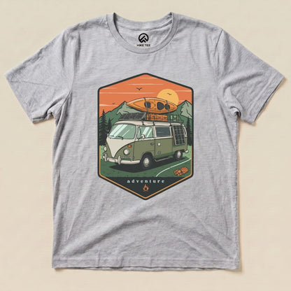 A graphic t-shirt featuring a green camping van with a kayak on top and the word "adventure" below, titled "Camping Van Adventure Shirt.
