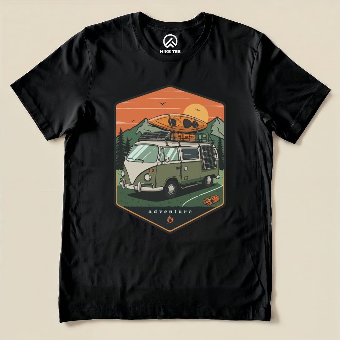 The graphic t-shirt features a vintage camping van with a kayak on top and mountain scenery, labeled "adventure" in an illustrated design.