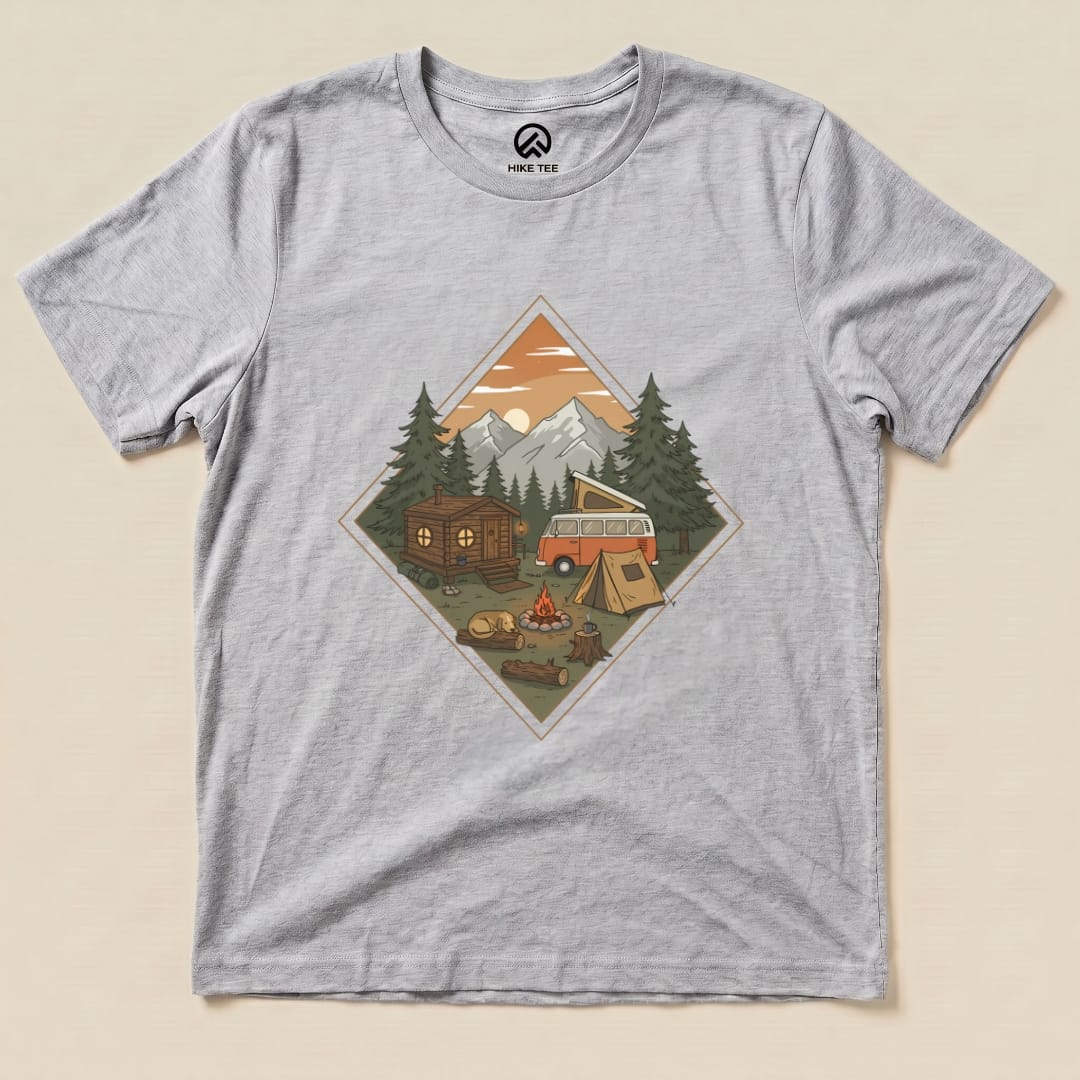 Graphic t-shirt featuring a camping scene with a vintage van, tent, campfire, and mountains, labeled "Camping Vibes Shirt.