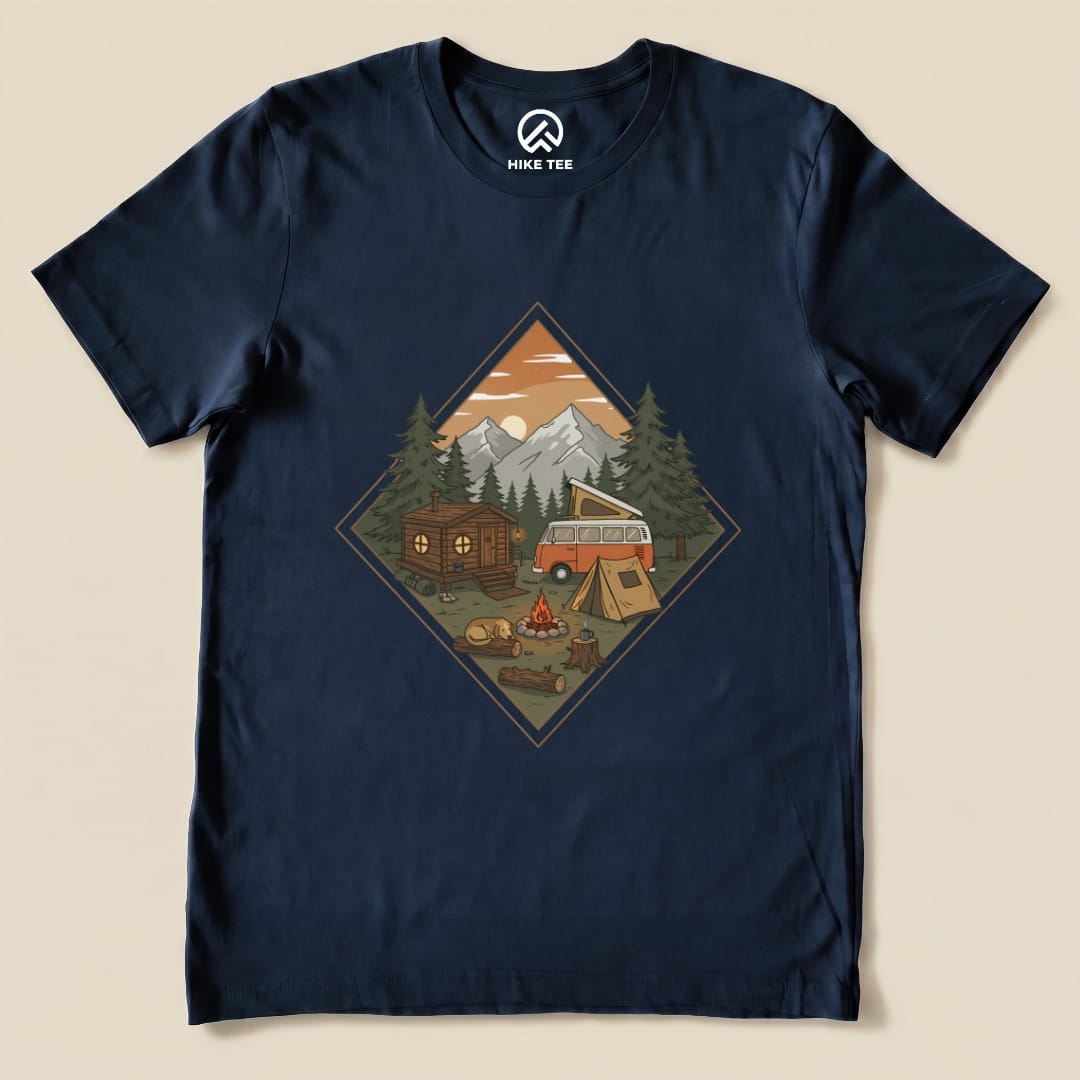 A graphic t-shirt featuring a camping scene with a vintage van, a cabin, tents, and a campfire, labeled "Camping Vibes Shirt.