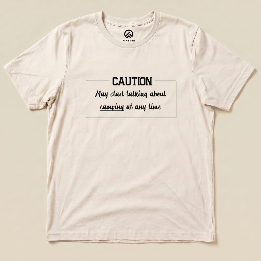 A flat graphic t-shirt features the slogan "Caution May start talking about camping at any time" in bold lettering.