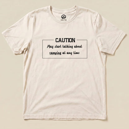 A flat graphic t-shirt features the slogan "Caution May start talking about camping at any time" in bold lettering.