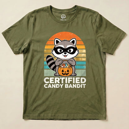 Military Green Certified Candy Bandit Shirt with a masked raccoon holding a pumpkin candy bucket graphic