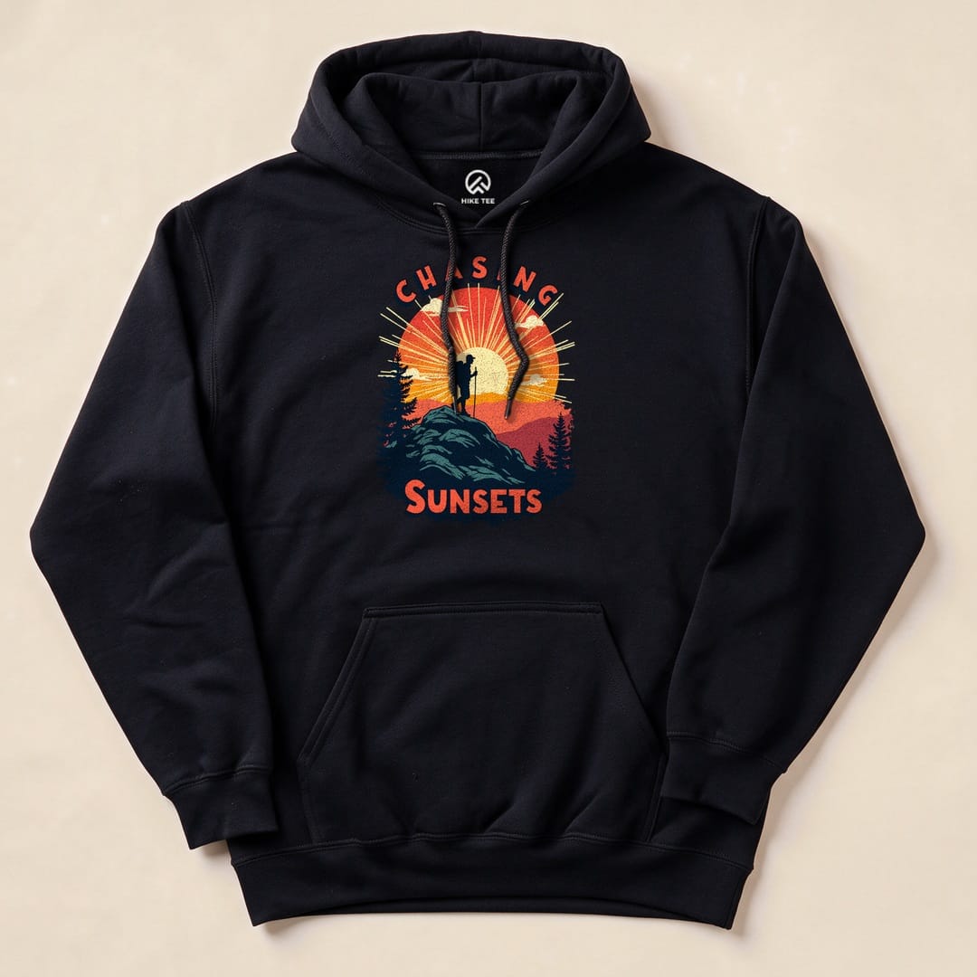 A black hoodie featuring the "Chasing Sunsets Hoodie" graphic with a silhouette of a hiker against a vibrant sunset backdrop.