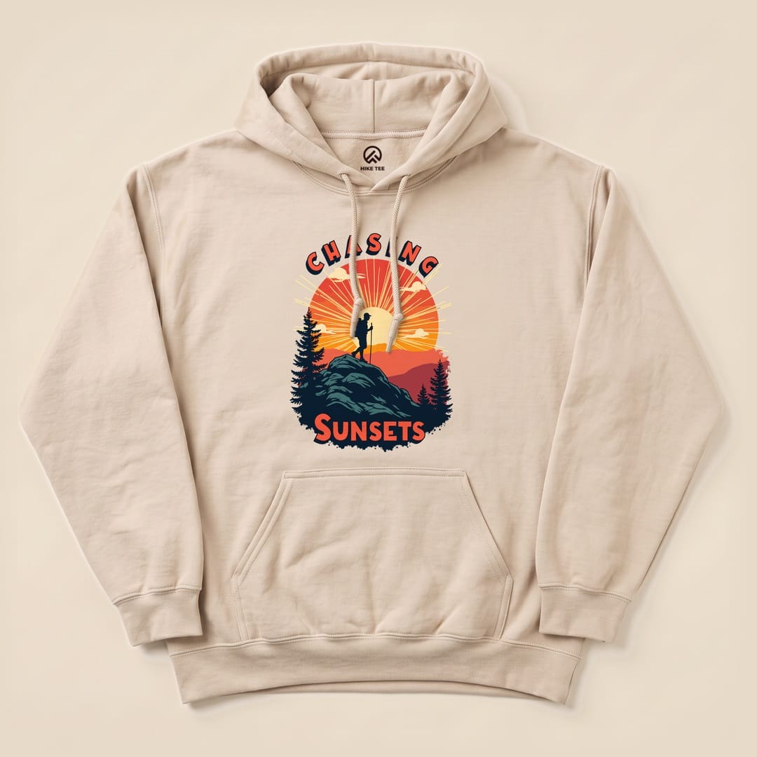The "Chasing Sunsets Hoodie" features a graphic of a hiker on a rock against a vibrant sunset backdrop with trees.