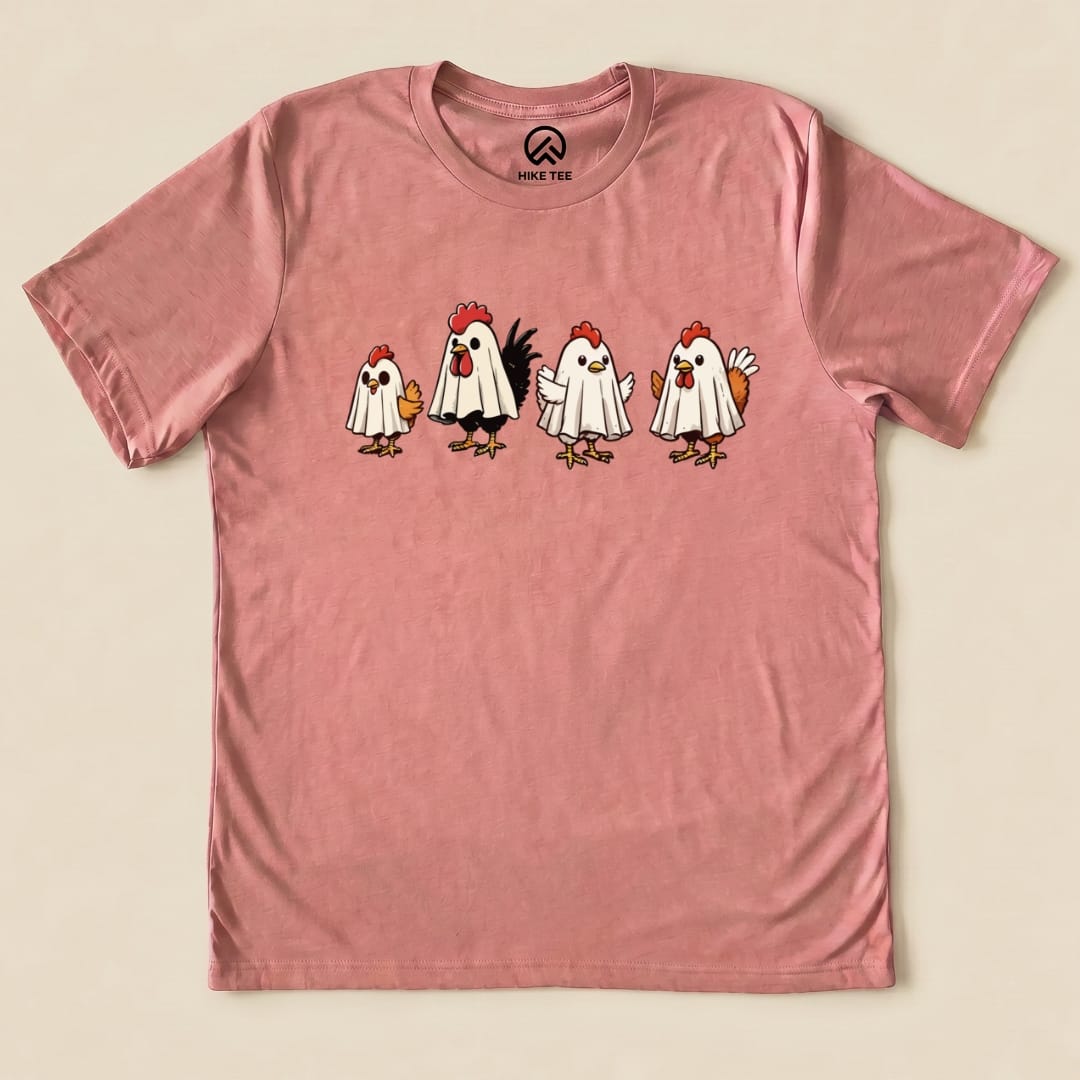 A graphic t-shirt featuring the "Chicken Ghost Shirt" design, showcasing five cartoon chickens dressed as ghosts on a pink background.
