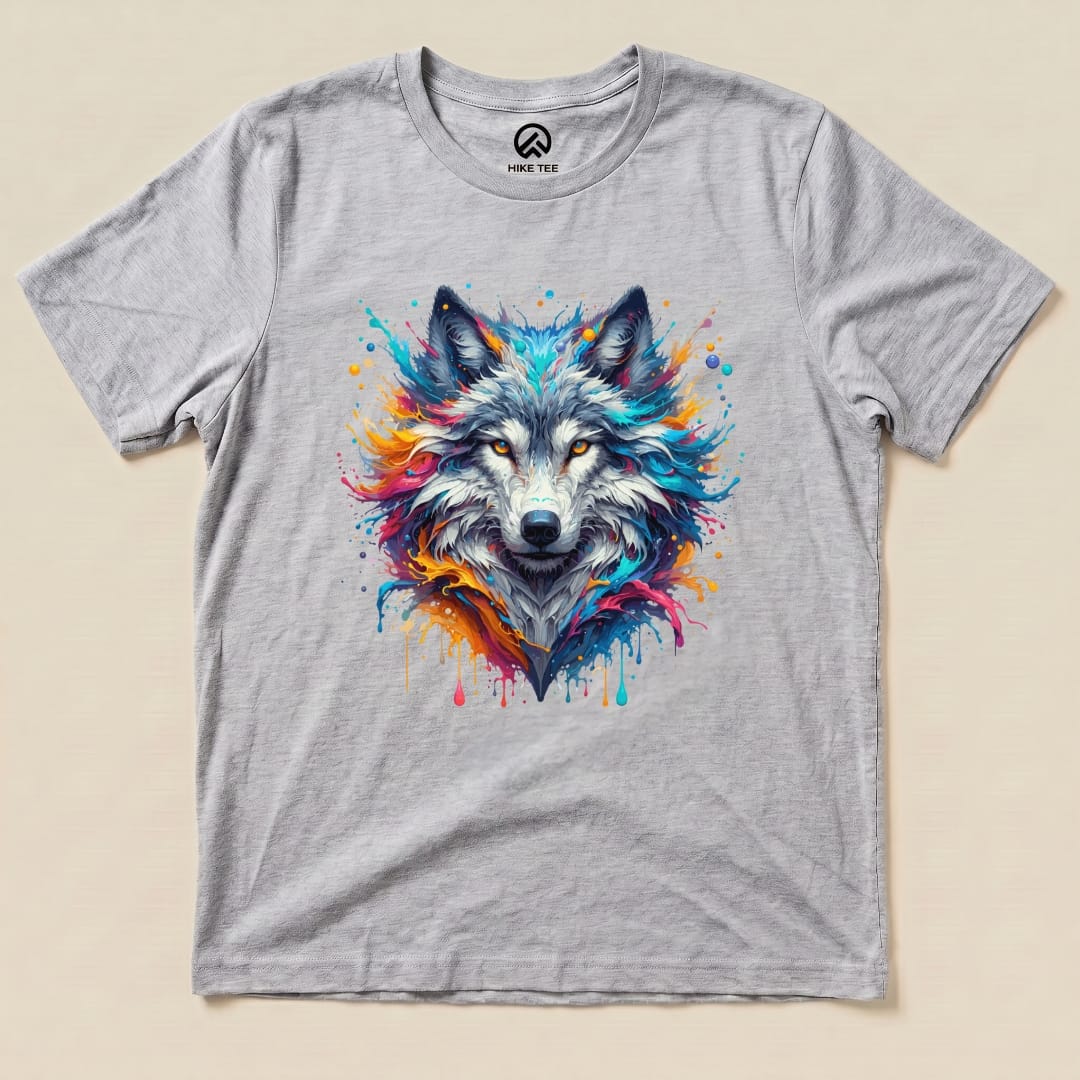 A graphic t-shirt featuring a vibrant, colorful wolf design with splashes of paint against a gray background.