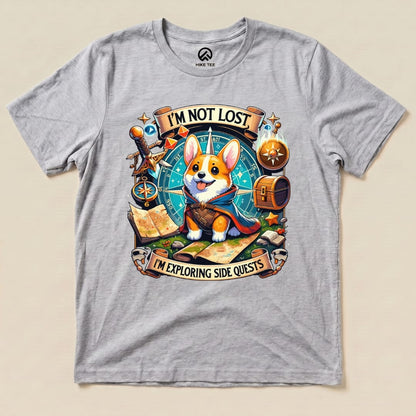 A graphic t-shirt featuring a playful corgi with the text "I'M NOT LOST, I'M EXPLORING SIDE QUESTS" surrounded by adventure-themed elements.