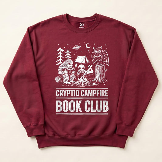 Maroon Cryptid Campfire Book Club Sweatshirt with a Bigfoot and friends reading around a campfire graphic