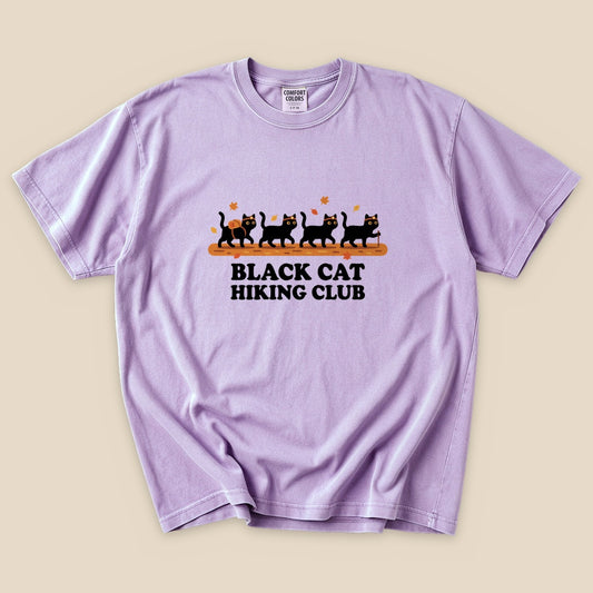 Orchid Black Cat Hiking Club T-Shirt with black cats hiking in a row graphic