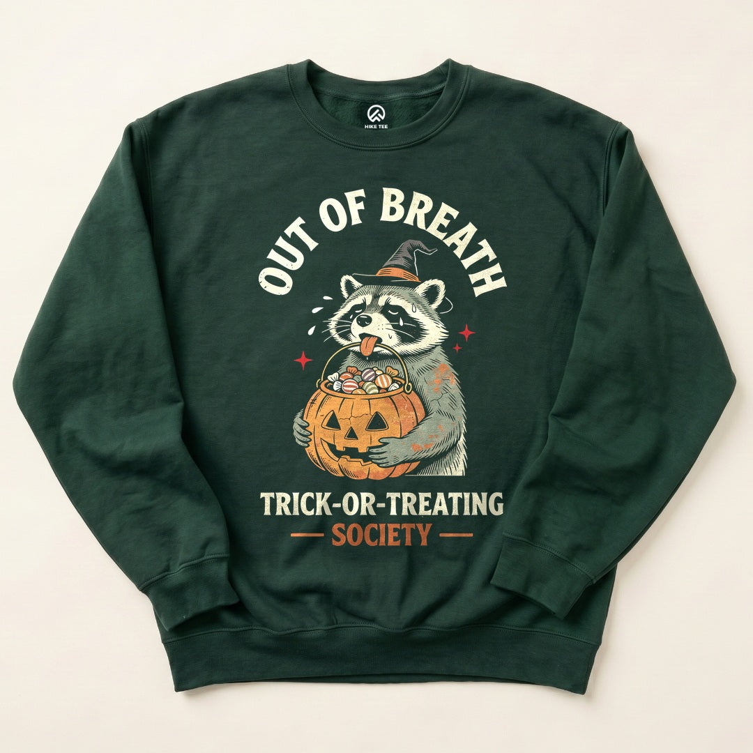 Forest Green Out of Breath Trick-or-Treating Society Sweatshirt with a tired raccoon holding a jack-o-lantern candy bucket graphic