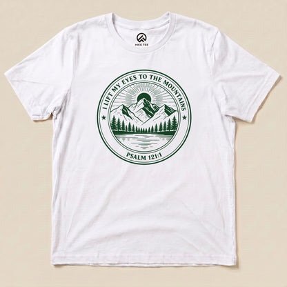 White I Lift My Eyes to the Mountains Shirt with a mountain lake badge with Psalm 121:1 graphic