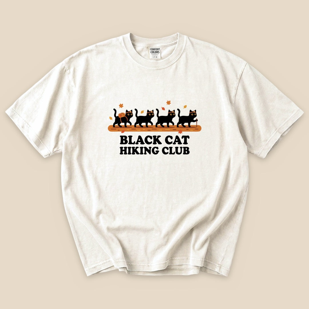 Ivory Black Cat Hiking Club T-Shirt with black cats hiking in a row graphic