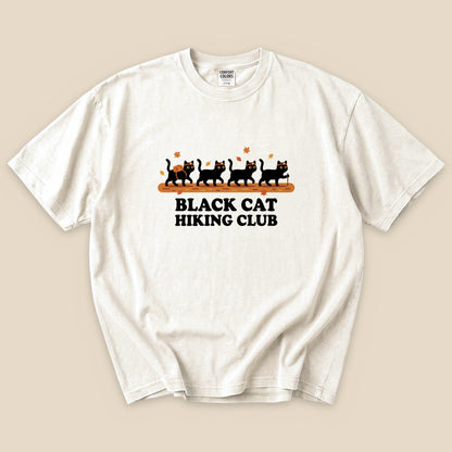 Ivory Black Cat Hiking Club T-Shirt with black cats hiking in a row graphic