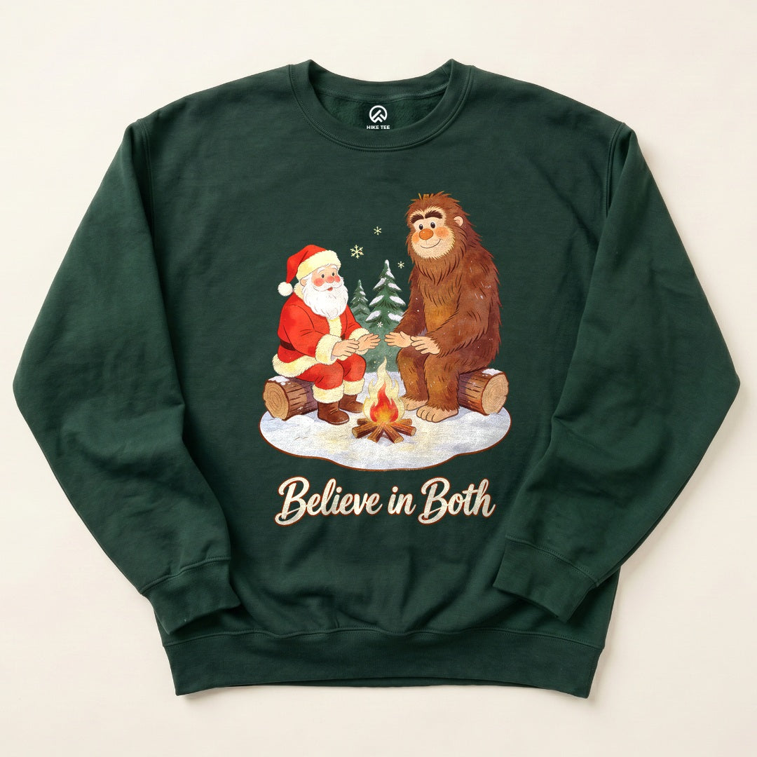 Forest Green Believe in Both Sweatshirt with a Santa and Bigfoot warming up by a campfire graphic