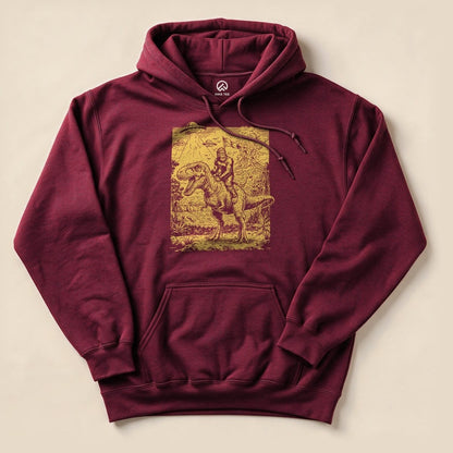 A maroon Bigfoot Dinosaur Hoodie featuring a graphic of Bigfoot riding a dinosaur in a forest setting.