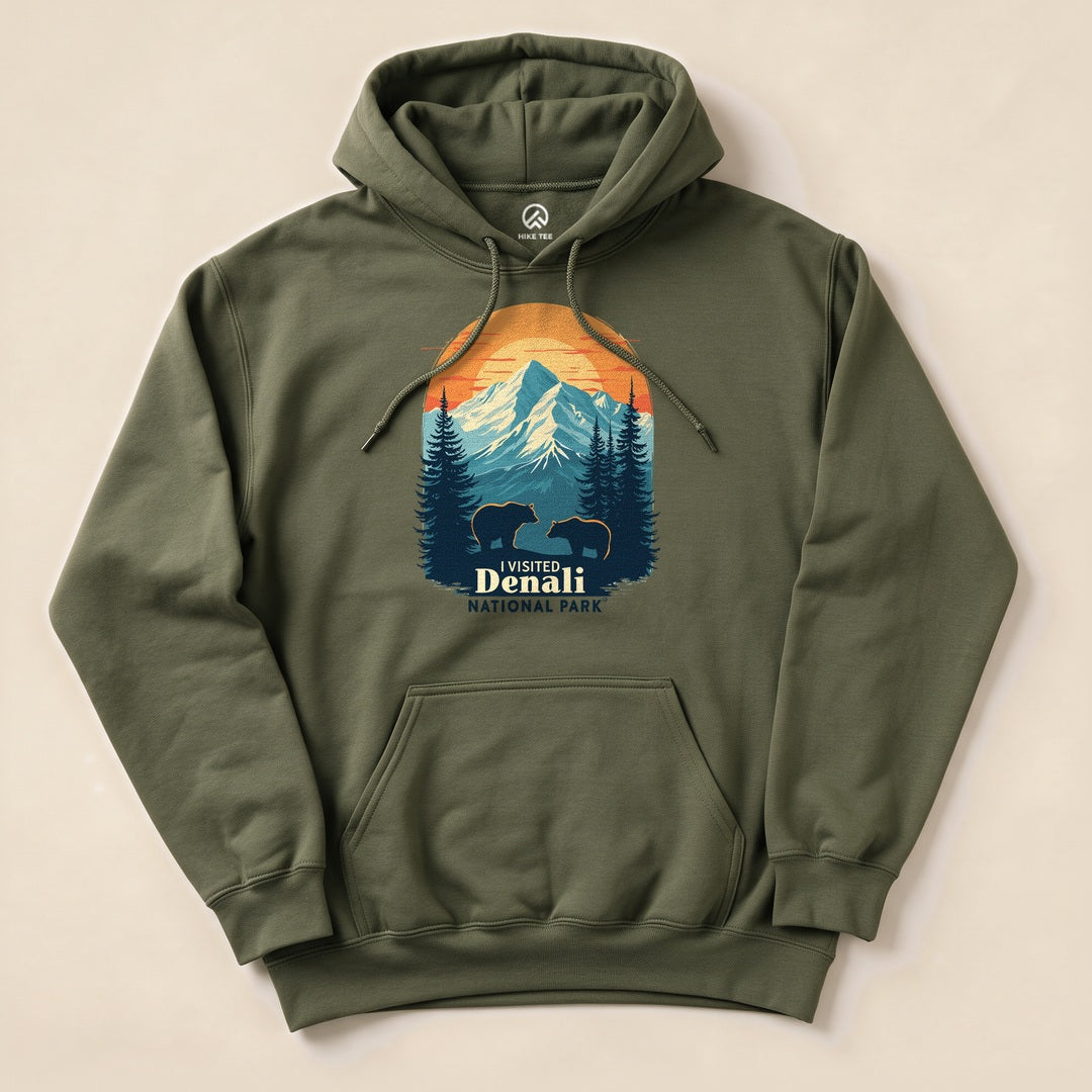 A graphic olive green "Denali National Park Hoodie" featuring a mountain scene with two bears and the text "I Visited Denali National Park.