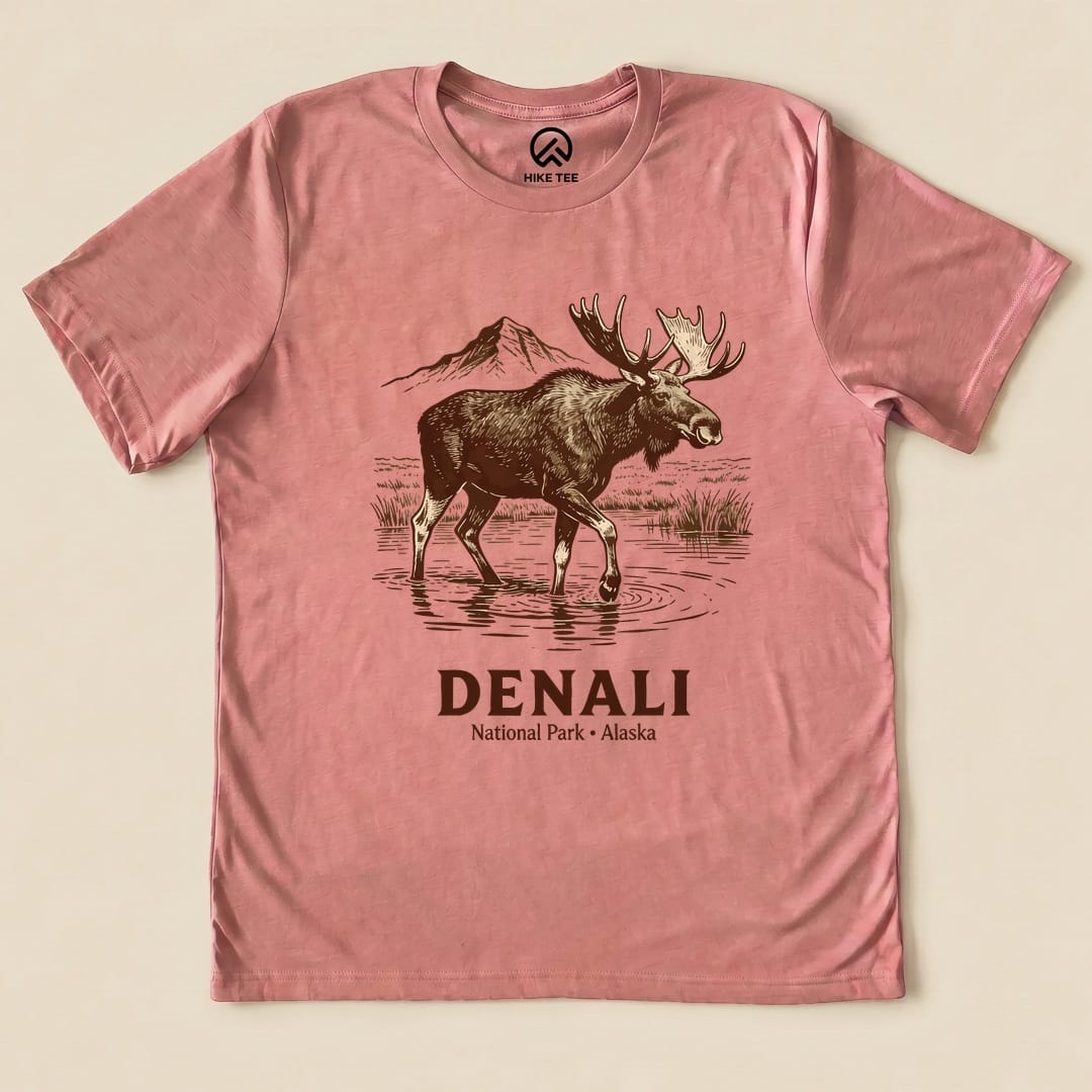 A pink graphic t-shirt features a moose standing in water with mountains in the background and the text "DENALI National Park - Alaska".