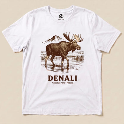 A graphic t-shirt featuring a moose standing in water with the text "DENALI National Park • Alaska" beneath it.