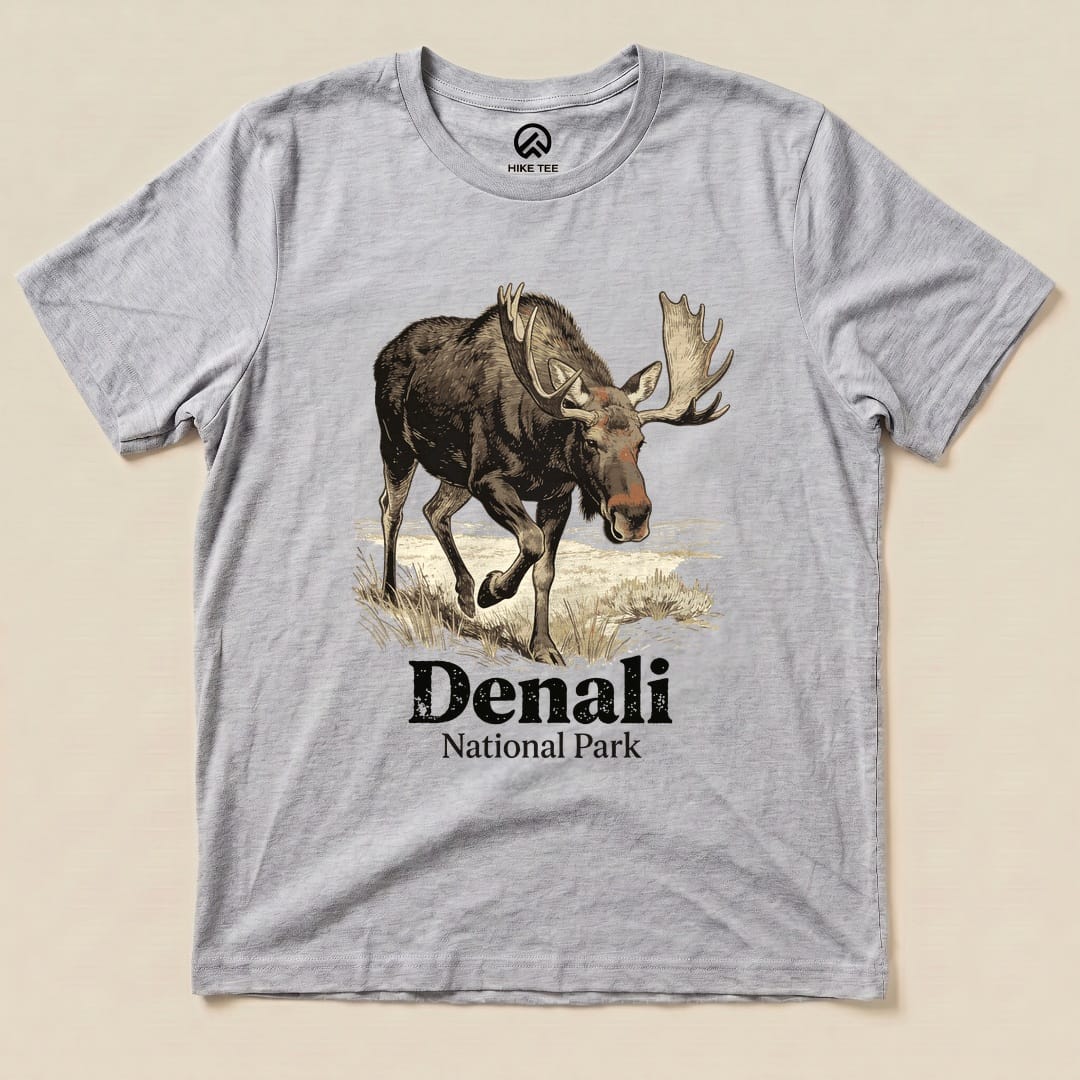 A gray graphic t-shirt features a moose illustration above the text "Denali National Park Shirt" in bold lettering.