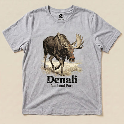 A gray graphic t-shirt features a moose illustration above the text "Denali National Park Shirt" in bold lettering.