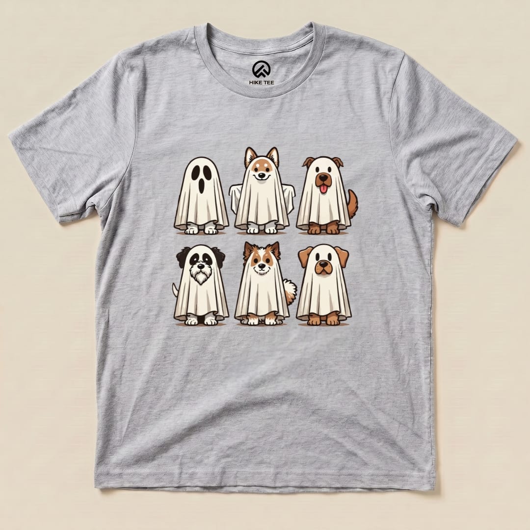 A graphic t-shirt featuring six cartoon dogs playfully dressed as ghosts on a light grey background, labeled as the "Dog Ghosts Shirt.