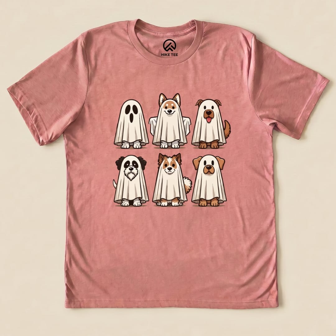 A pink graphic t-shirt featuring six cute dogs dressed as ghosts in playful poses, labeled as the "Dog Ghosts Shirt.