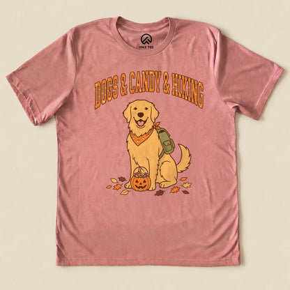 The graphic t-shirt features a cheerful golden retriever with a backpack and a pumpkin, surrounded by autumn leaves, captioned "Dogs & Candy & Hiking Shirt.