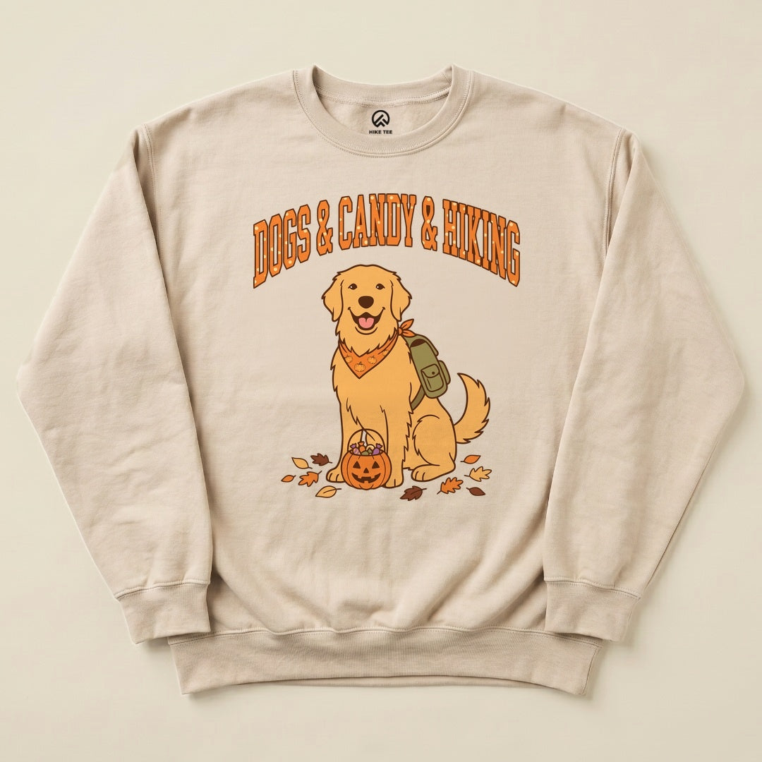 A graphic sweatshirt featuring a cheerful golden retriever with a pumpkin and the text "Dogs & Candy & Hiking" displayed above.