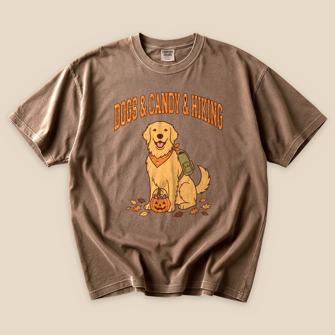 A graphic t-shirt featuring a golden retriever with a backpack and a pumpkin, labeled "Dogs & Candy & Hiking.