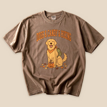 A graphic t-shirt featuring a golden retriever with a backpack and a pumpkin, labeled "Dogs & Candy & Hiking.