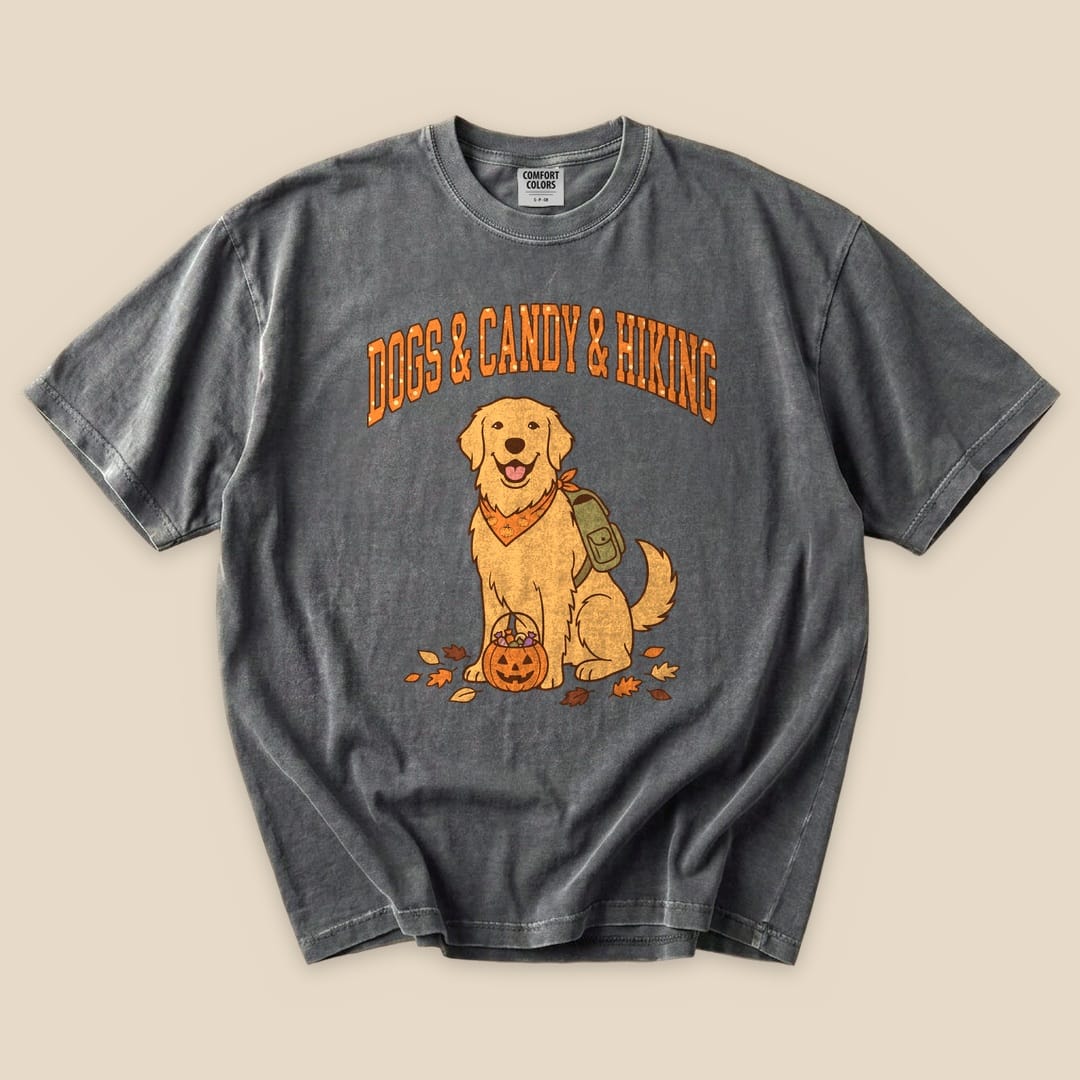 A graphic t-shirt featuring a happy golden retriever with a pumpkin basket, featuring the text "Dogs & Candy & Hiking.