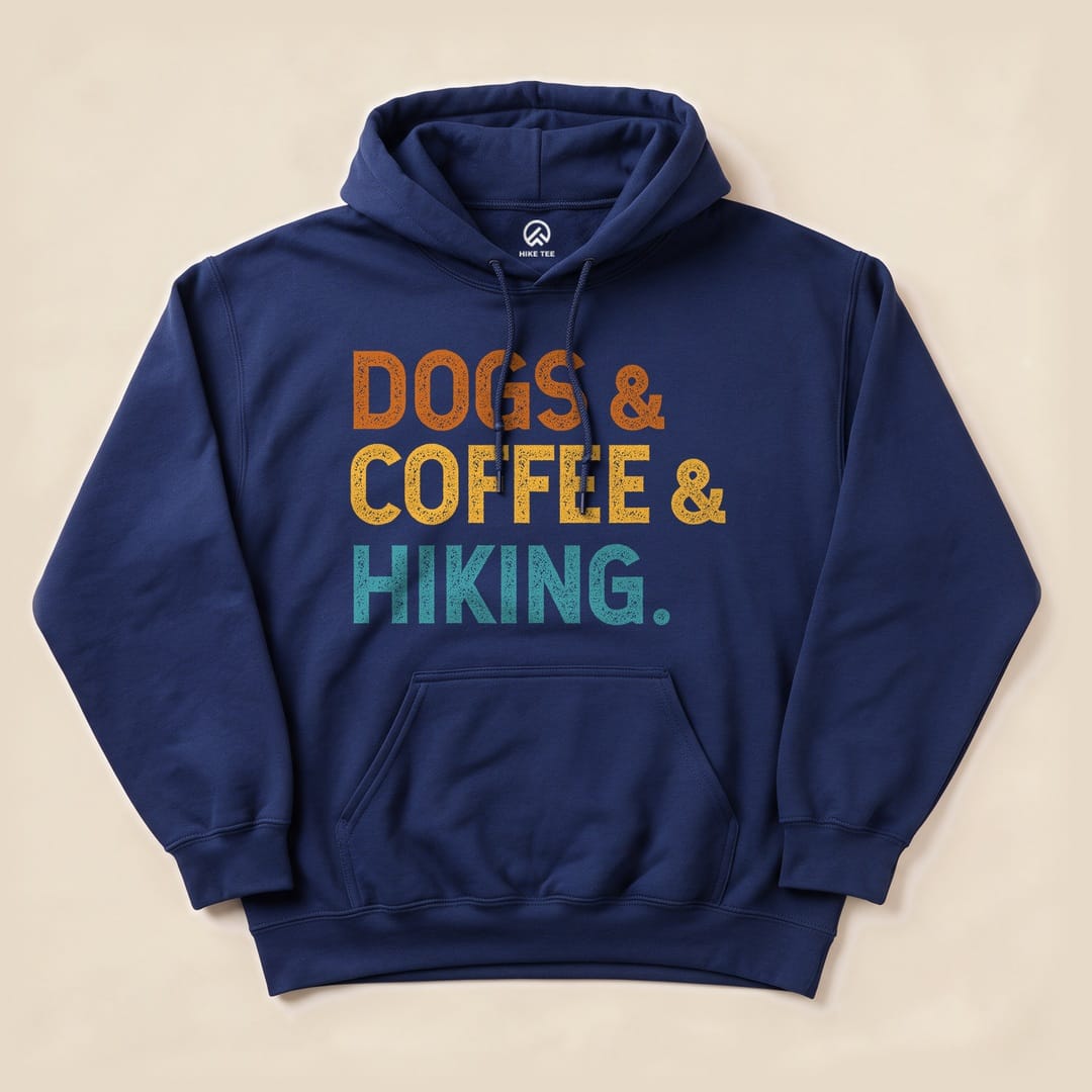 A navy hoodie features a graphic design with the words "DOGS & COFFEE & HIKING" in bold, colorful lettering.
