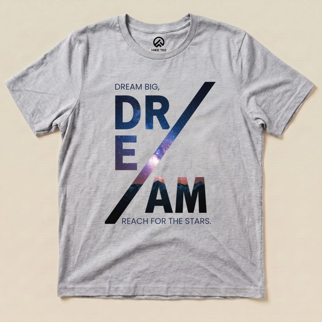 A graphic t-shirt featuring the words "Dream Big, DREAM" with a cosmic design, alongside "Reach for the Stars," labeled as a Dream Motivational Shirt.