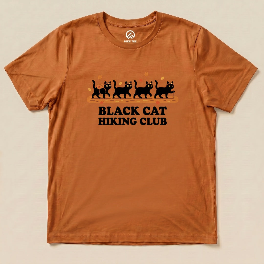 Autumn Black Cat Hiking Club Shirt with a row of black cats walking on a log with autumn leaves graphic