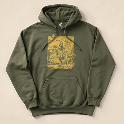 A graphic t-shirt featuring a humorous design of Bigfoot riding a dinosaur against a detailed backdrop, labeled "Bigfoot Dinosaur Hoodie.