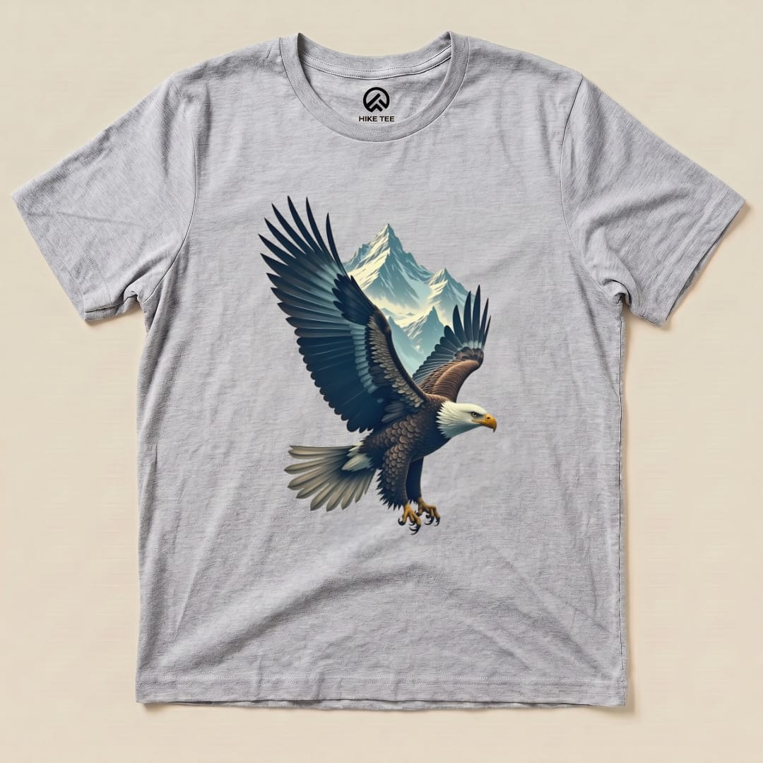 A graphic t-shirt featuring an eagle in flight with mountains in the background, labeled as the "Eagle and Mountain Shirt.