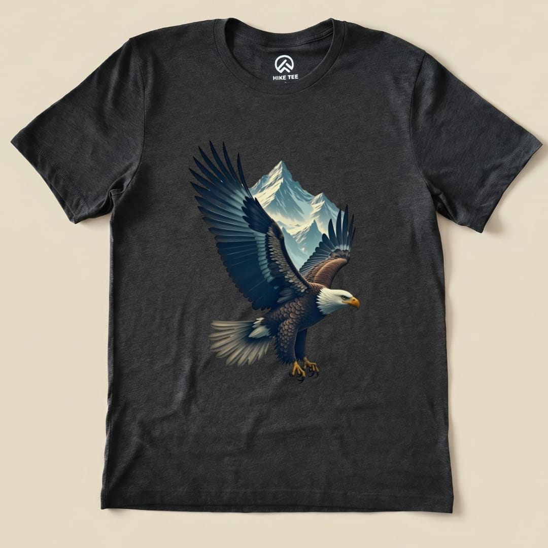 A graphic t-shirt featuring an eagle soaring in front of a mountain range, part of the Eagle and Mountain Shirt collection.