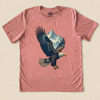 A graphic t-shirt featuring a soaring eagle and mountain design on a pink background, labeled as the Eagle and Mountain Shirt.