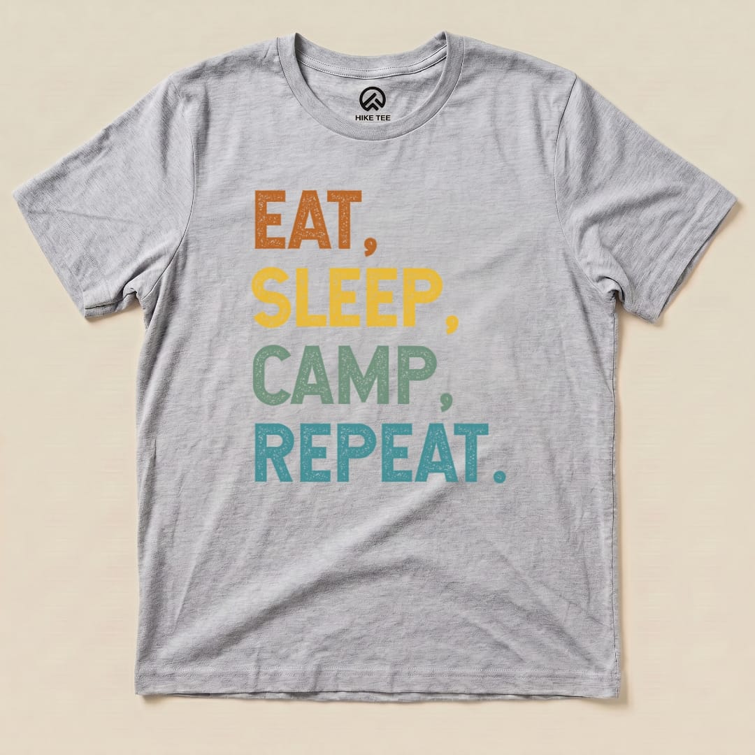 A light gray graphic t-shirt features the phrase "Eat, Sleep, Camp, Repeat" in bold, colorful letters.