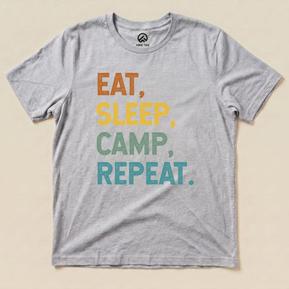A light gray graphic t-shirt features the phrase "Eat, Sleep, Camp, Repeat" in bold, colorful letters.