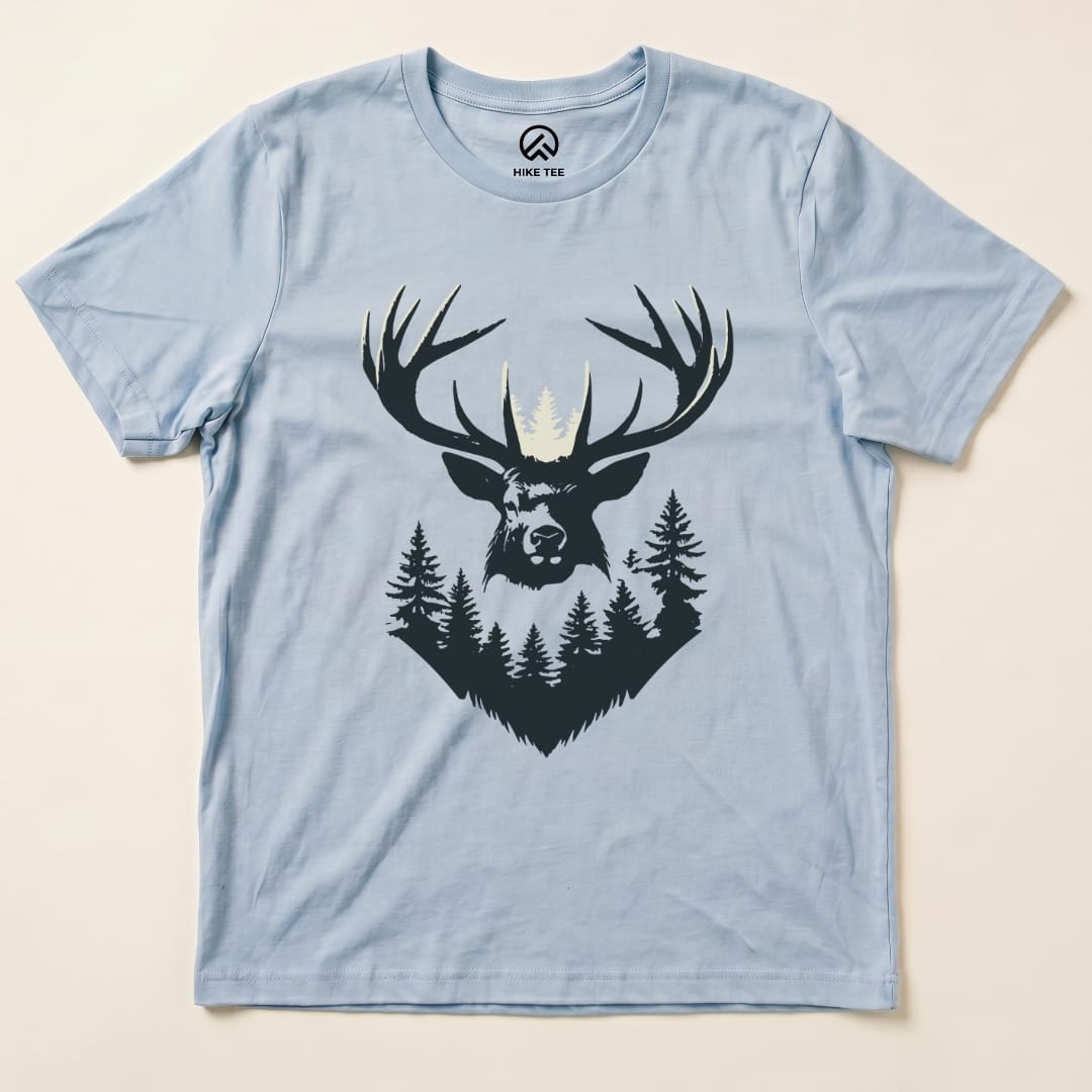 A light blue graphic t-shirt featuring an elk head with antlers surrounded by trees, labeled as the Elk Shape Shirt.