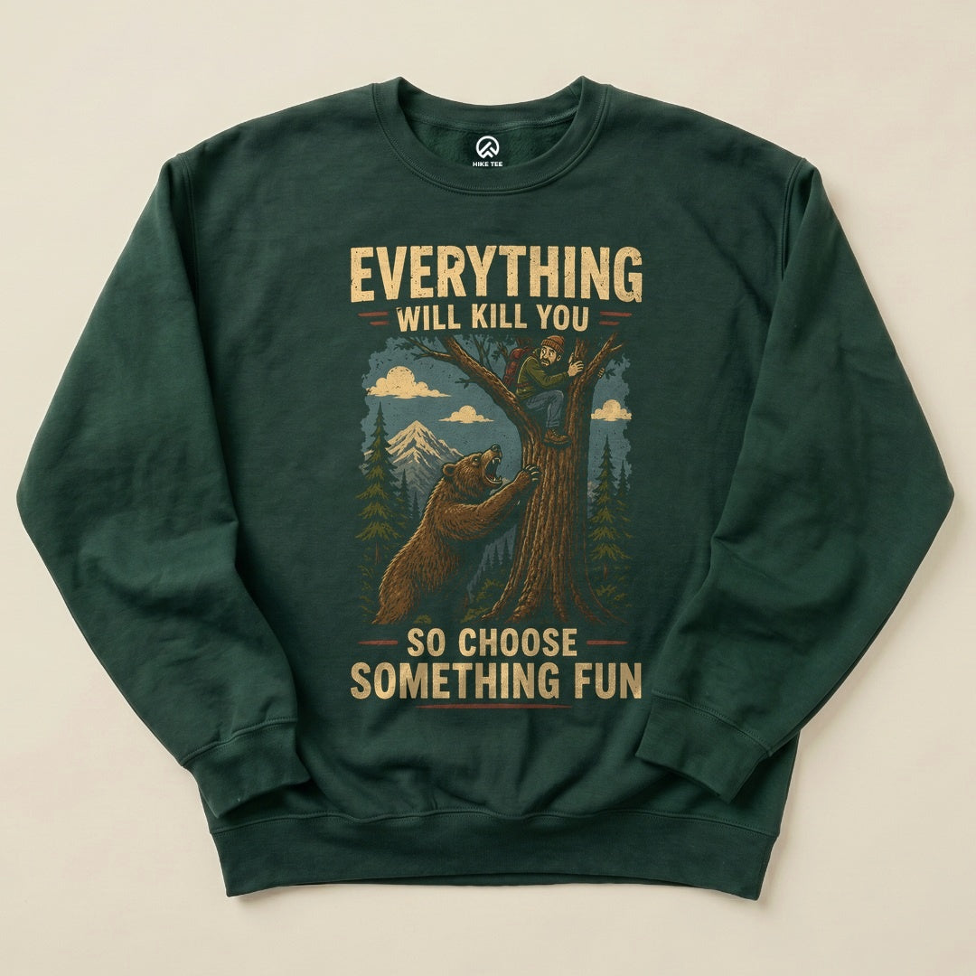 A dark green "Everything Will Kill You Sweatshirt" features a humorous graphic of a bear and a man in a tree, with mountains in the background.